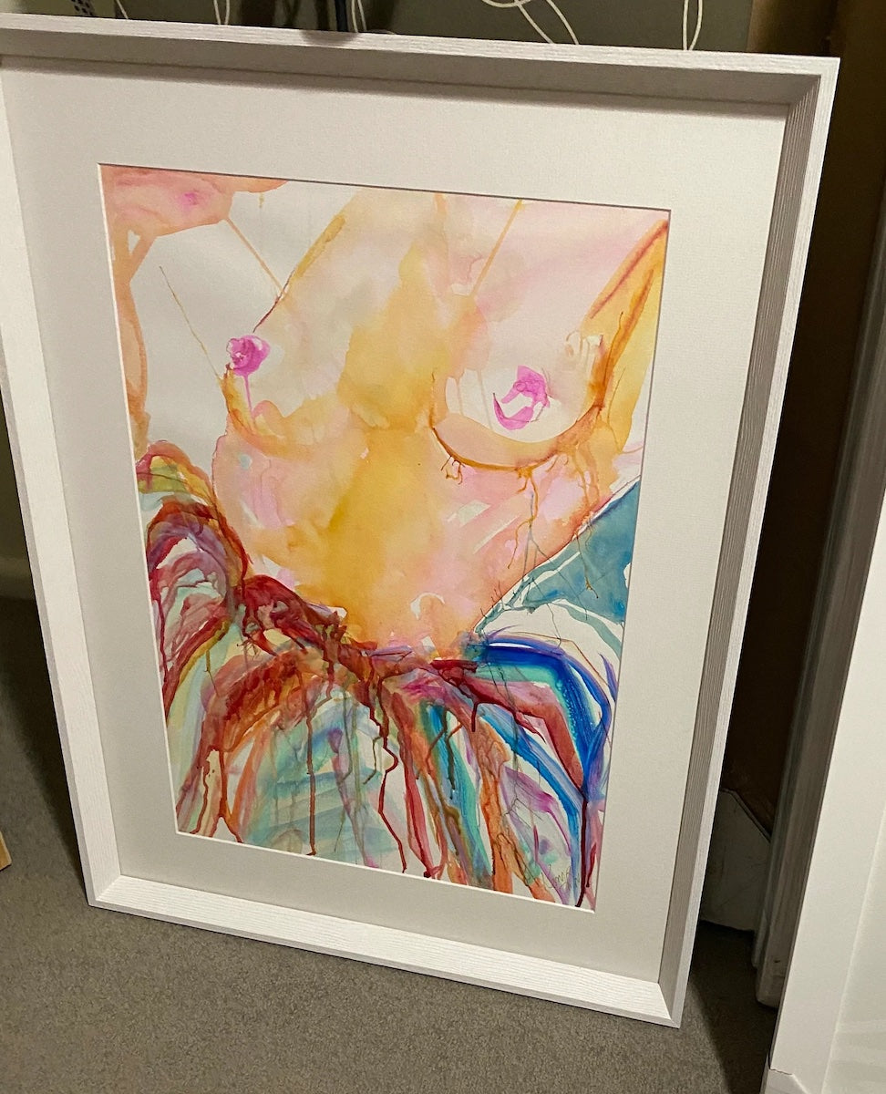 Woman nude from the waist up and wearing a multi coloured skirt. In frame.