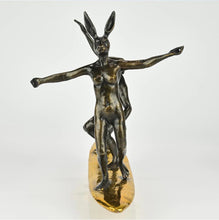 Load image into Gallery viewer, Bronze sculpture of a dog man and rabbit woman on a surfboard with gold patina. Front view.