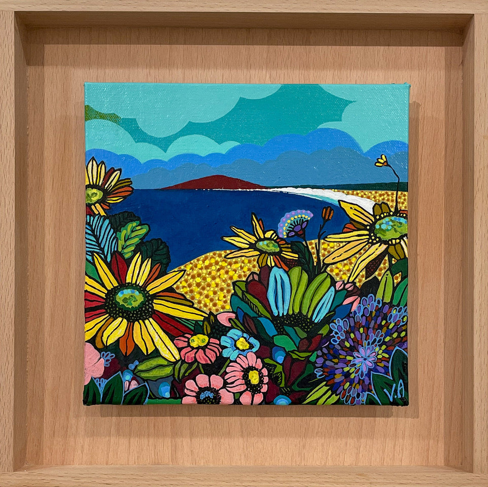 Colourful painting of a sapphire blue ocean, a mountain in the background and multi-coloured blooms in the foreground. Framed in Tasmanian Oak.