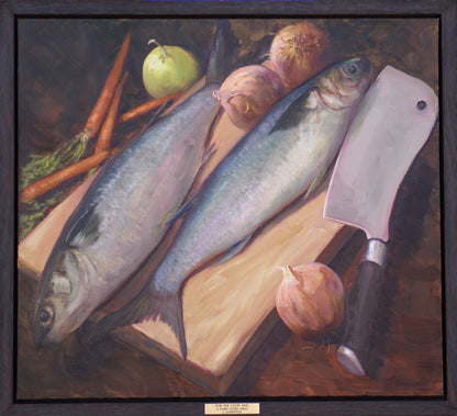 Preparations for a meal with two fish, onions and carrots on a chopping board next to a cleaver. Framed view.