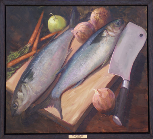Preparations for a meal with two fish, onions and carrots on a chopping board next to a cleaver. Framed view.