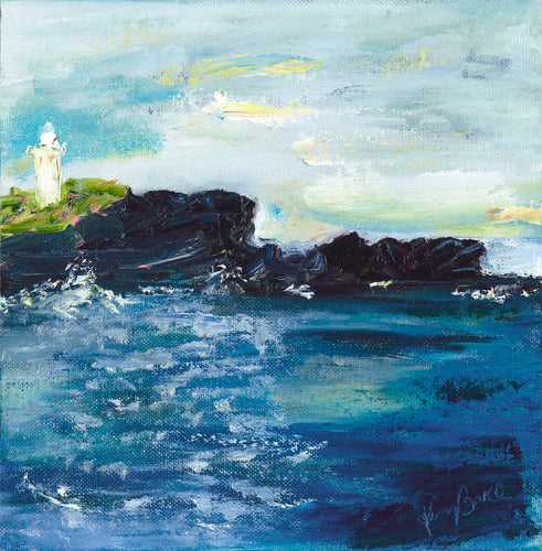 Kiama Lighthouse on a black rocky headland against a sapphire ocean and pastel sky