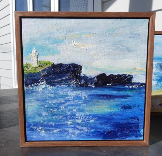 Lighthouse in Kiama on the NSW South Coast showing a black rocky headland against a sapphire ocean and pastel sky. Framed in an oak float frame