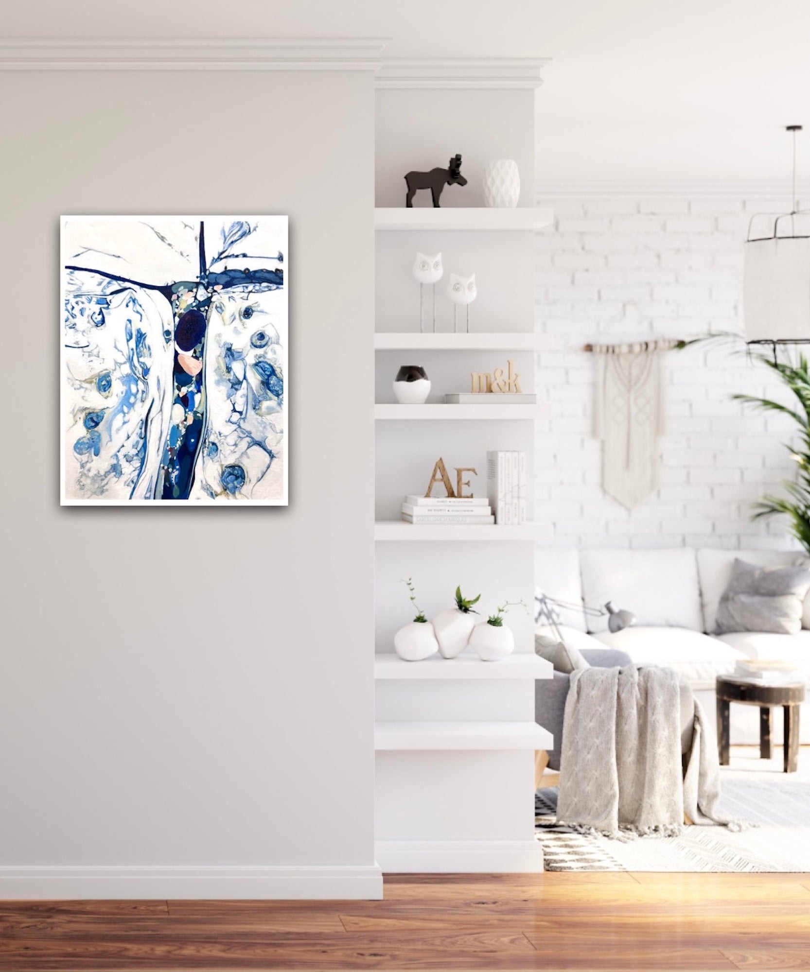 Abstract oil painting on a white background in shades of blue. Shown on a sitting room wall.