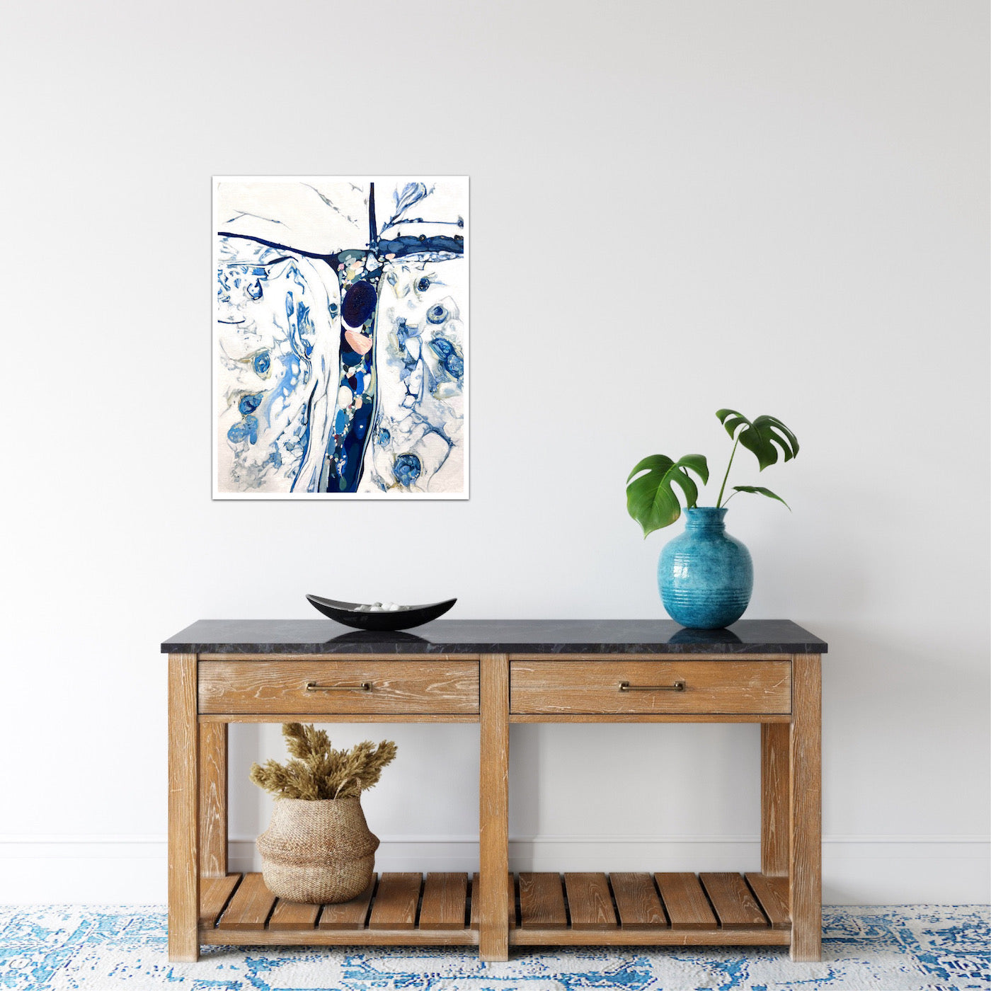 Abstract oil painting on a white background in shades of blue. Shown on a  wall.