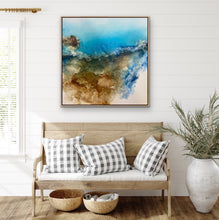 Load image into Gallery viewer, Rocky coastal headland painted in an abstract style, showing the ocean in a bright aqua with white sand. In situ on a white wall.
