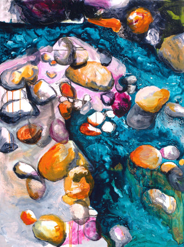 Brightly coloured pebbles on the edge of a rock pool.