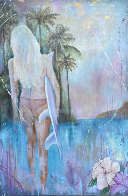 Girl in a bikini holding a surfboard standing in front of aqua blue water and palm trees.