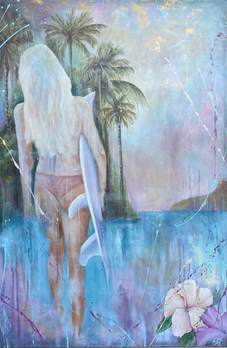Girl in a bikini holding a surfboard standing in front of aqua blue water and palm trees.