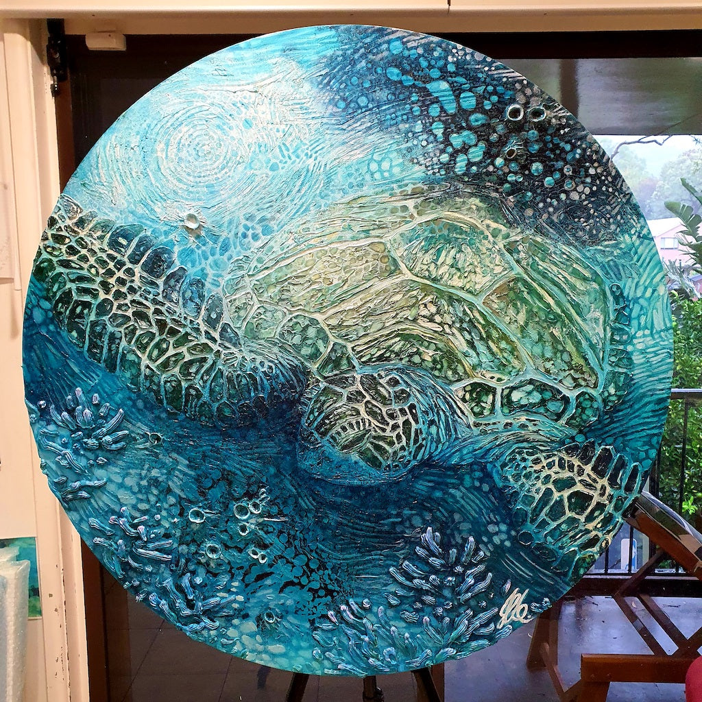 Round canvas, one metre in diameter original artwork depicting a green sea turtle swimming in the ocean. Calming soothing colours in this painting in shades of blue, turquoise, aqua and green.
