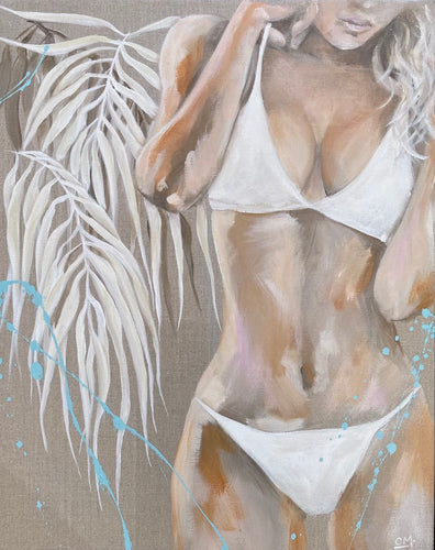 A girl in a white bikini standing next to white fringed leaves against a background of neutral tones with a splash of blue.