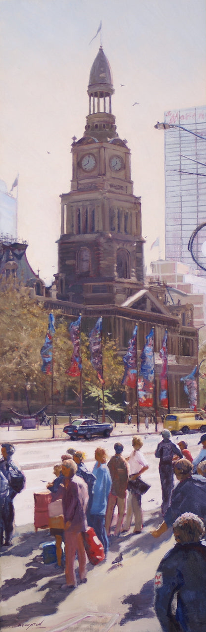 Street scene of pedestrians waiting for a green light to cross the road near the Town Hall in Sydney NSW.