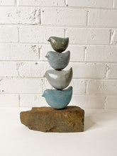 Load image into Gallery viewer, Ceramic bird totem sculpture with 4 ceramic birds sitting on a piece of ochre coloured river stone.

