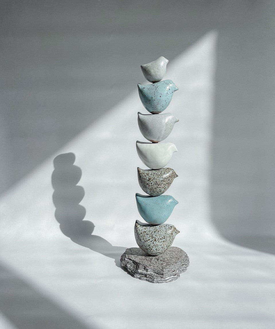 Ceramic Totem sculpture with 7 ceramic birds in shades of pale blue, white, pale grey and speckled grey.