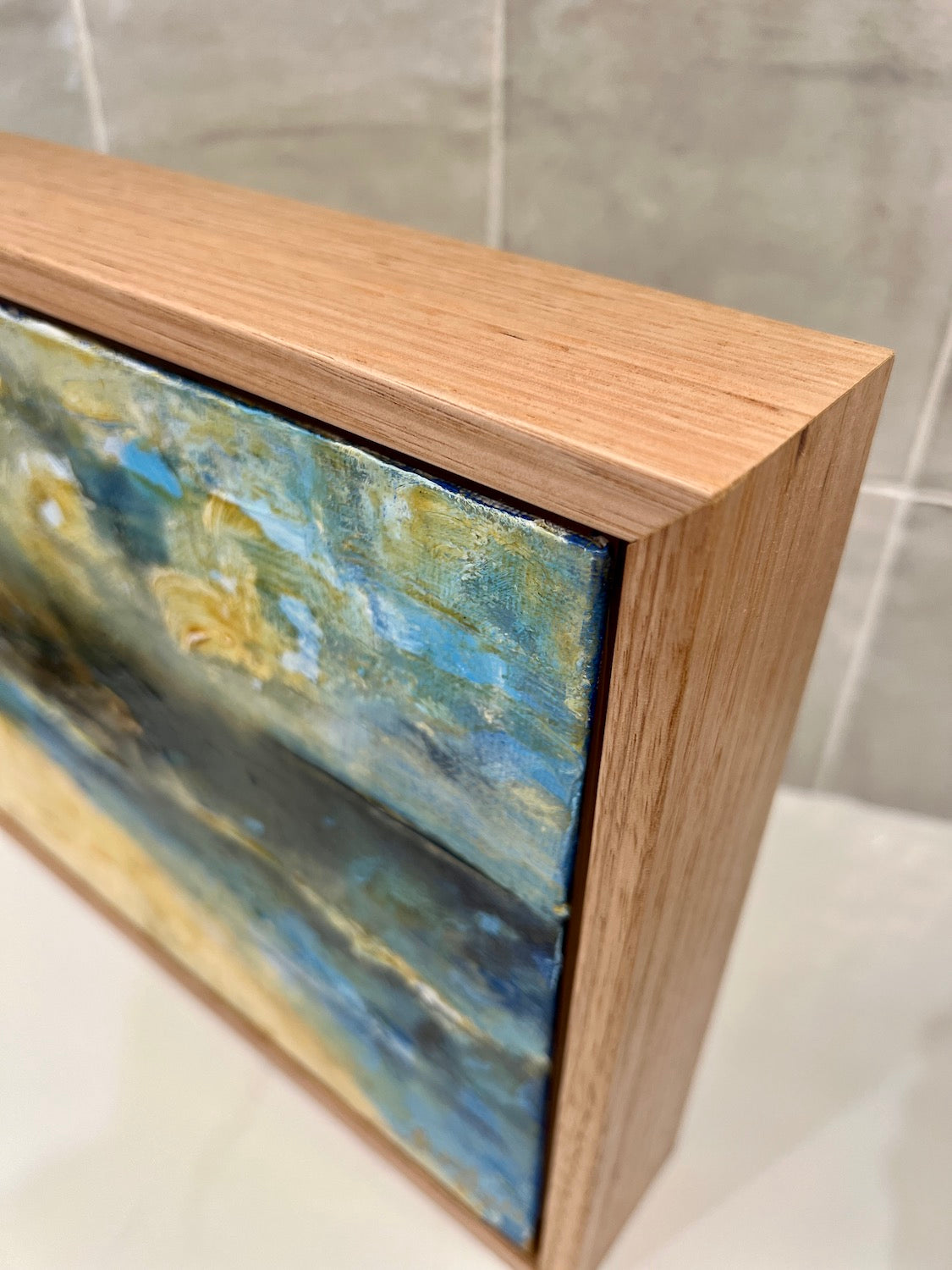 Abstract coastal scene in shades of yellow and blue. Side View.