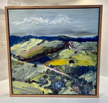 Load image into Gallery viewer, Abstract oil painting of a country landscape with steep hills and lots of colour, yellow, pink, green and blue against a pale blue sky with white clouds. Framed View.

