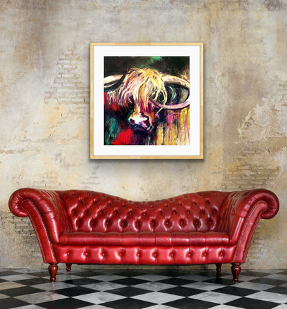A lovely limited edition print of Curly the bull with his head against a background of emerald, red, gold, pink and black, shown in situ in a living room on a brick wall above a red sofa.