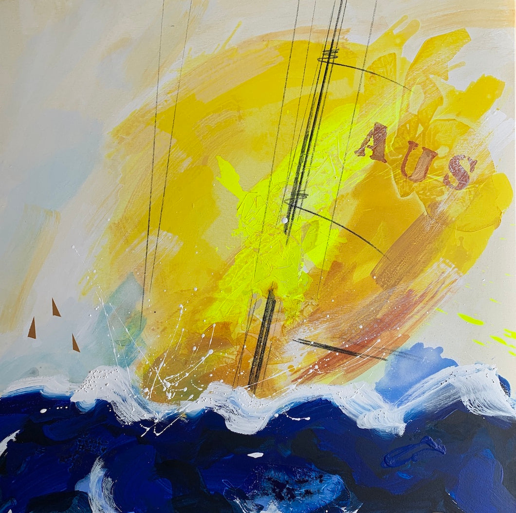 Sailing boat with the letters AUS on a bright yellow spinnaker with flashes of fluro yellow in a deep blue ocean and tiny tan coloured sails in the background.