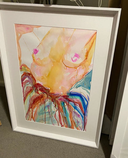 Woman nude from the waist up and wearing a multi coloured skirt. In frame.