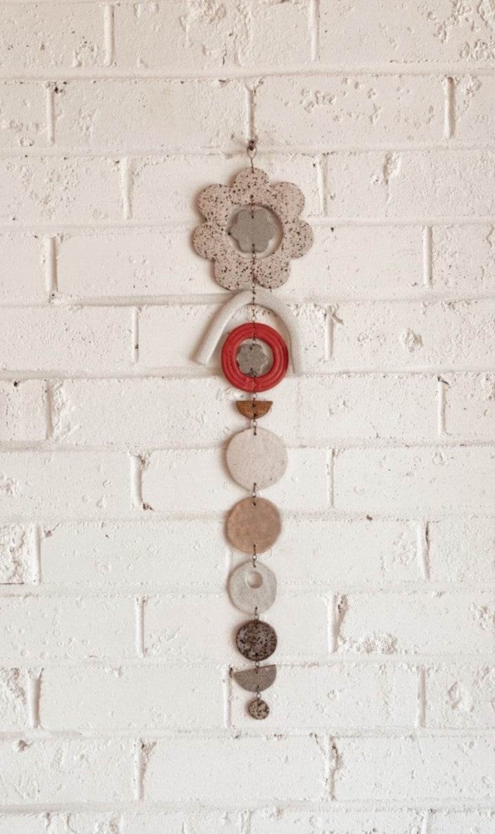 Flower hanging wall piece made of ceramic, clays, glazes and wire in shades of red, copper and natural.