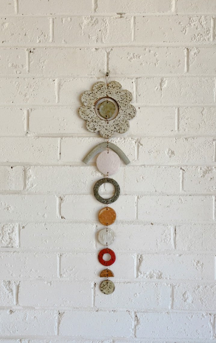 Flower hanging wall piece made of ceramic, clays, glazes and wire in shades of natural, copper and red.