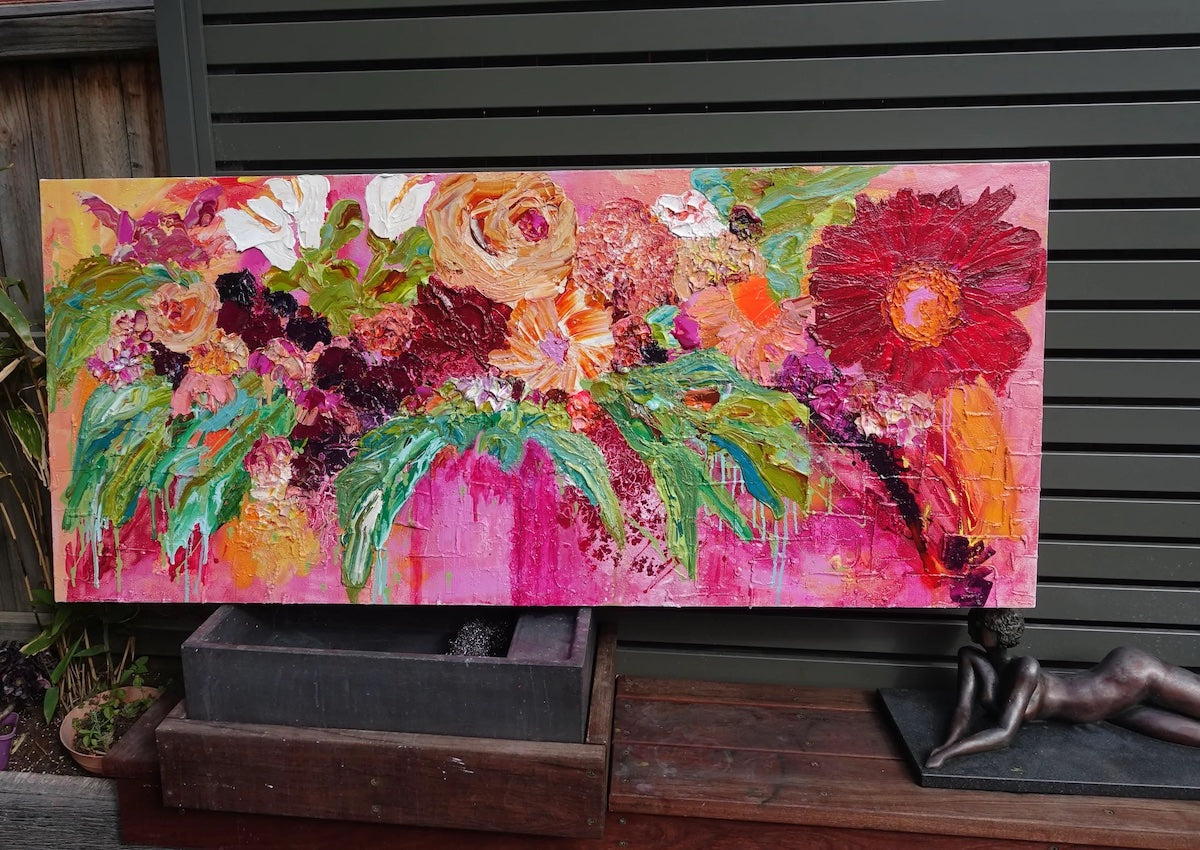 Multicoloured blooms against a hot pink background. In situ view.