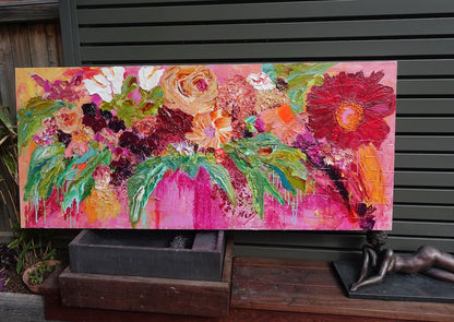 Multicoloured blooms against a hot pink background. In situ view.