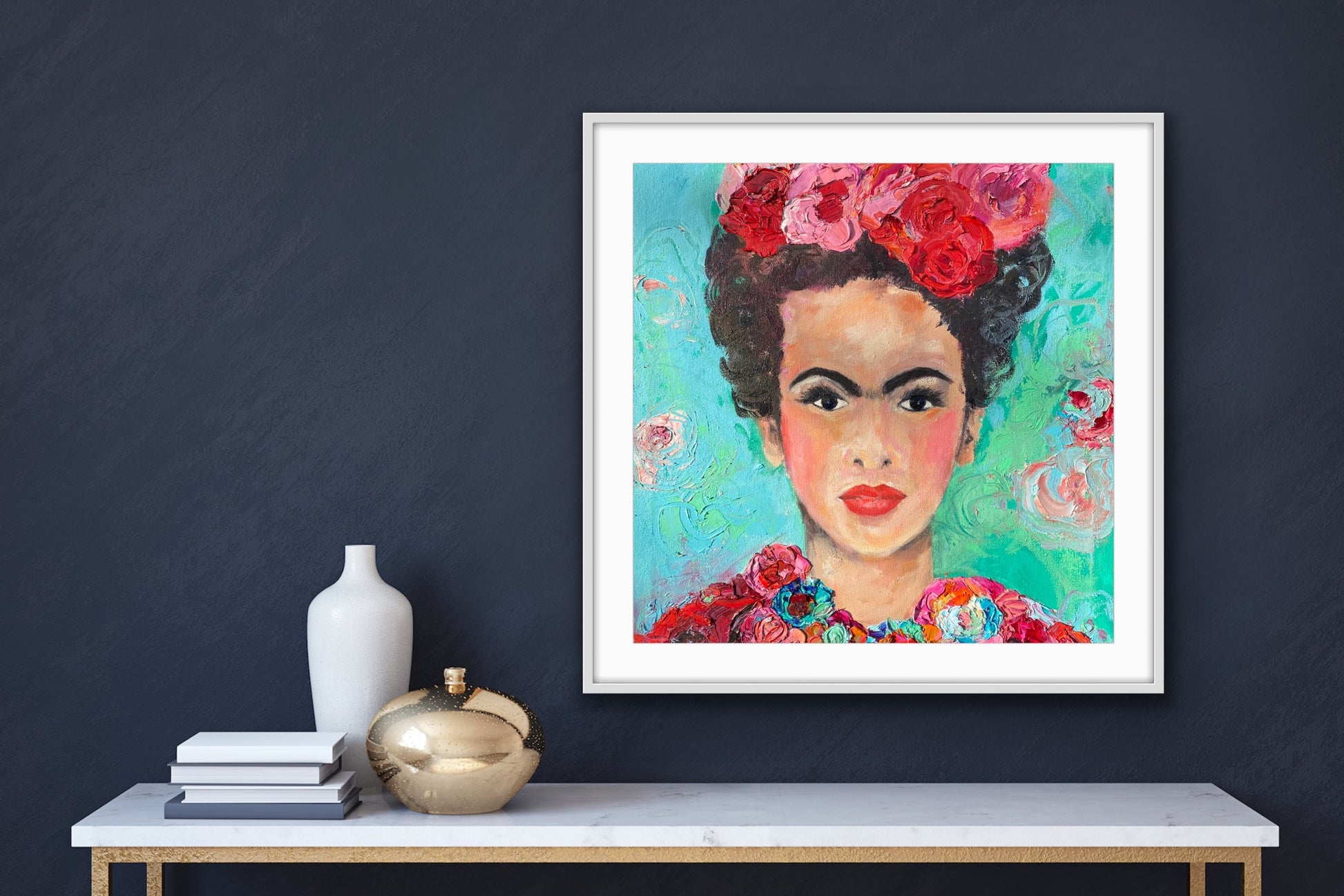 A beautiful and colourful limited edition print of Frida Kahlo with red and pink flowers in Frida's hair against a turquoise and aqua background, framed in white.