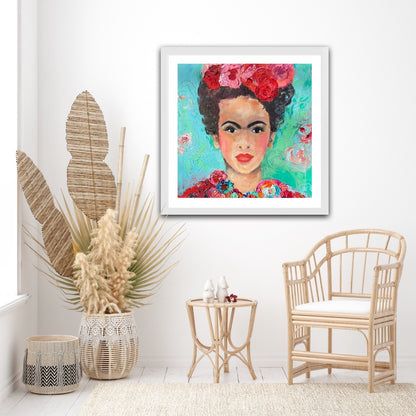A beautiful and colourful limited edition print of Frida Kahlo with red and pink flowers in Frida's hair against a turquoise and aqua background shown on a white wall.