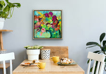 Load image into Gallery viewer, A mass of gorgeous blooms in shades of green, pink, magenta, red and gold in a green glass vase shown in situ in a dining room.
