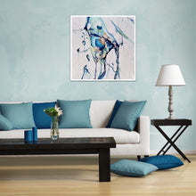 Load image into Gallery viewer, Abstract painting with a background of mostly white with blues and multi coloured detail. Shown on pale blue living room wall.
