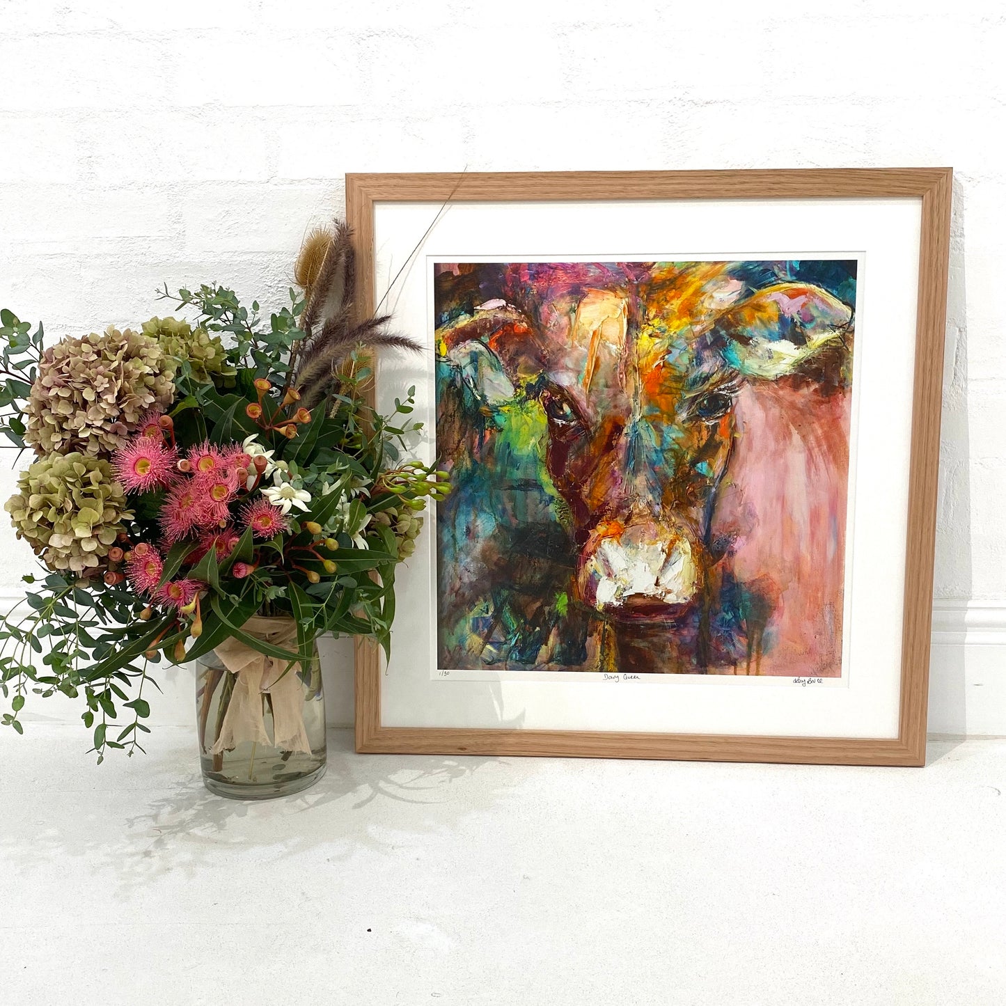 A gorgeous limited edition print of Dairy Queen the cow. Set against a muted, multi coloured background, in a Tasmanian Oak frame.