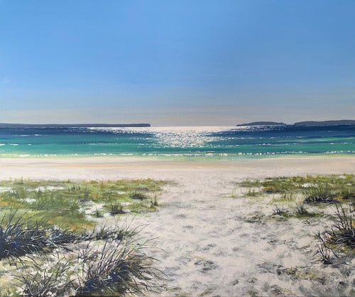 The white sand, tufts of grass and emerald ocean waters of Blenheim Beach at Jervis Bay on the NSW South Coast. Looking to Point Perpendicular in the distance.