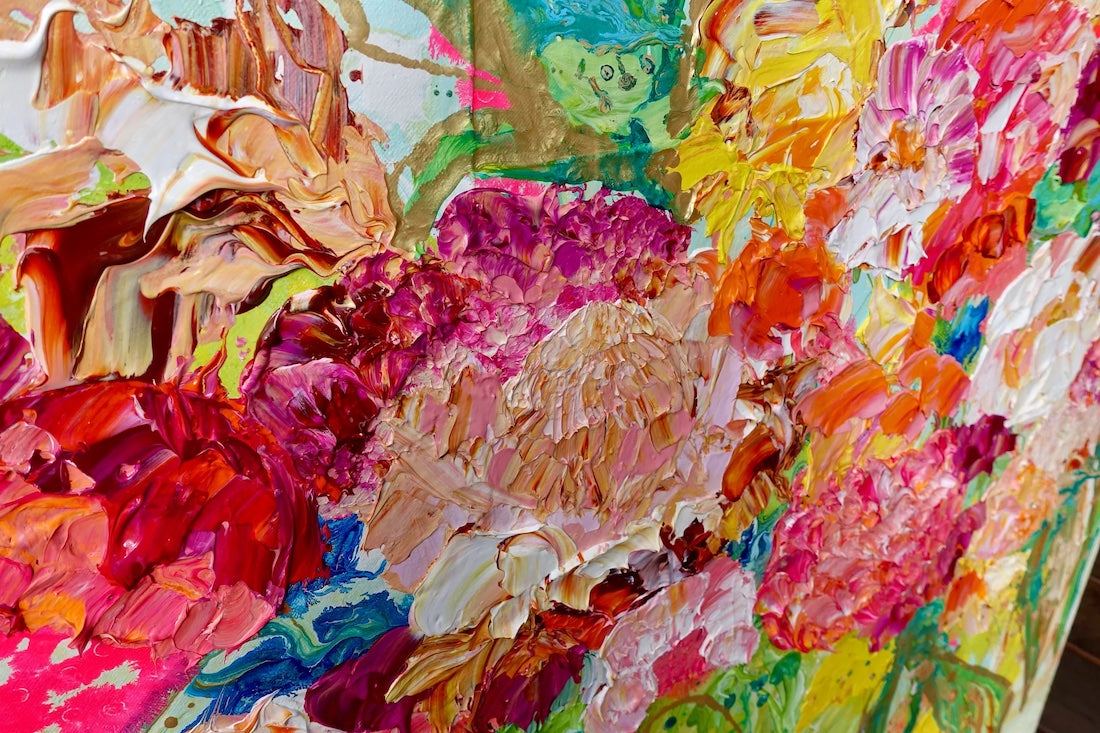 Pink, cream and yellow blooms in a green vase against a pale green background. Detail view 2.