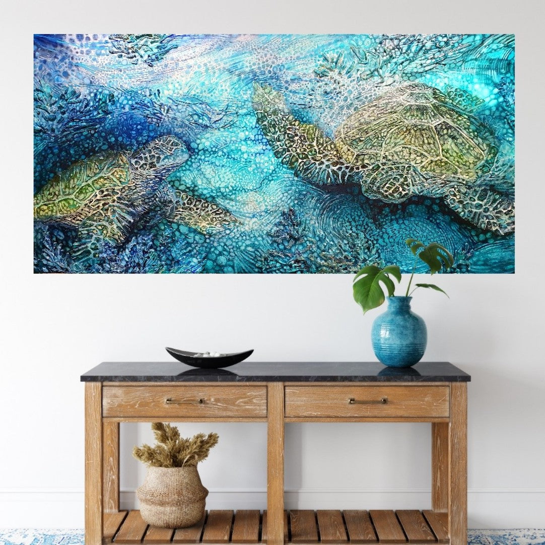 Painting of green sea turtles swimming in the ocean. Calming soothing colours in this painting in shades of blue, turquoise, aqua and green. Shown in situ on a white wall.