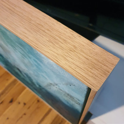 Multi-coloured painting of an ocean pool. clasp view of the Tasmanian Oak frame.