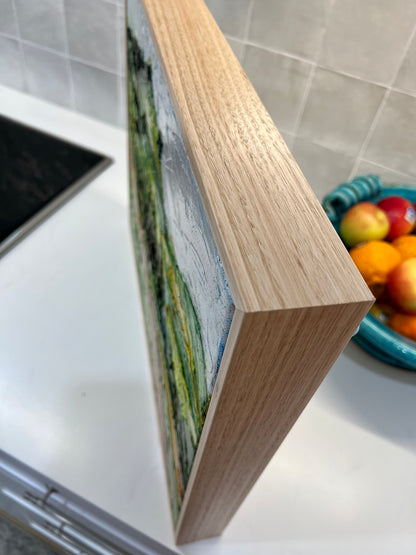 Abstract landscape of rolling green and yellow hills and a winding pink road.  View of corner of frame.