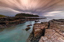 Load image into Gallery viewer, Coastal rock platform against a sunray filled sky.
