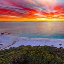 Load image into Gallery viewer, Hyams Beach, Jervis Bay NSW at sunrise with a vibrant orange and yellow sky above the white sand and turquoise waters of the Bay. Square view.

