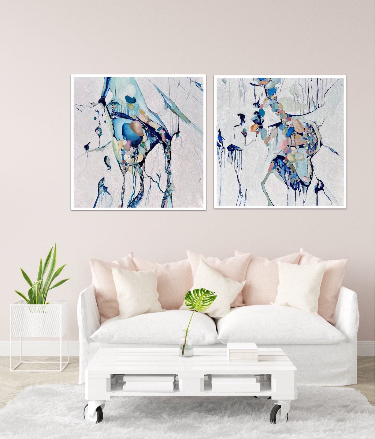 Abstract painting of a cluster of stones in a tidal pool with a background of mostly white with blues and multi coloured detail. Shown on a wall next to a matching artwork.