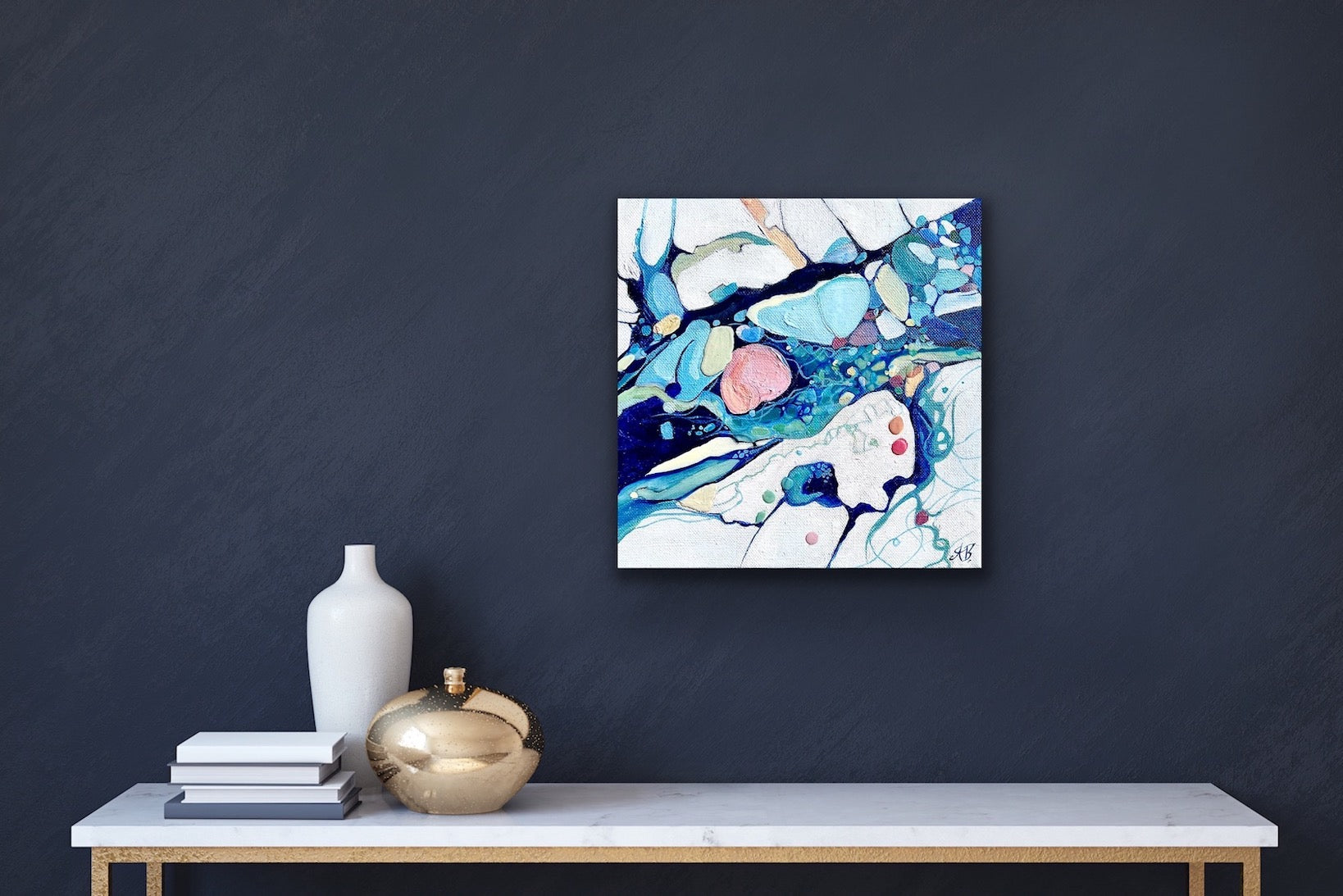 Contemporary abstract painting depicting a rock pool in shades of blue, aqua, turquoise, rose, mauve, pink ochre and white. Shown on a navy blue wall.