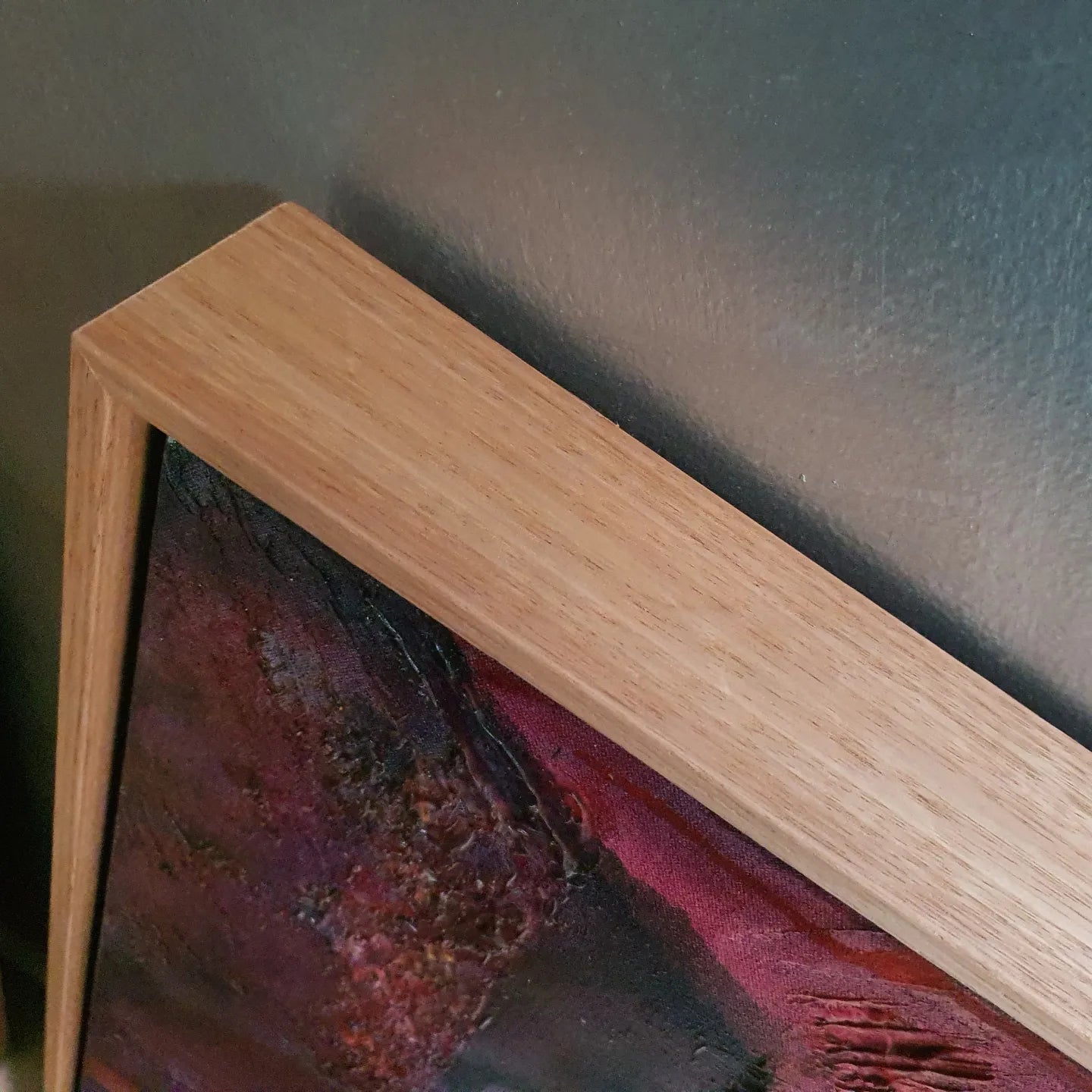 Crimson coloured abstract painting of a sea urchin. Closeup view of the Tasmanian Oak frame.