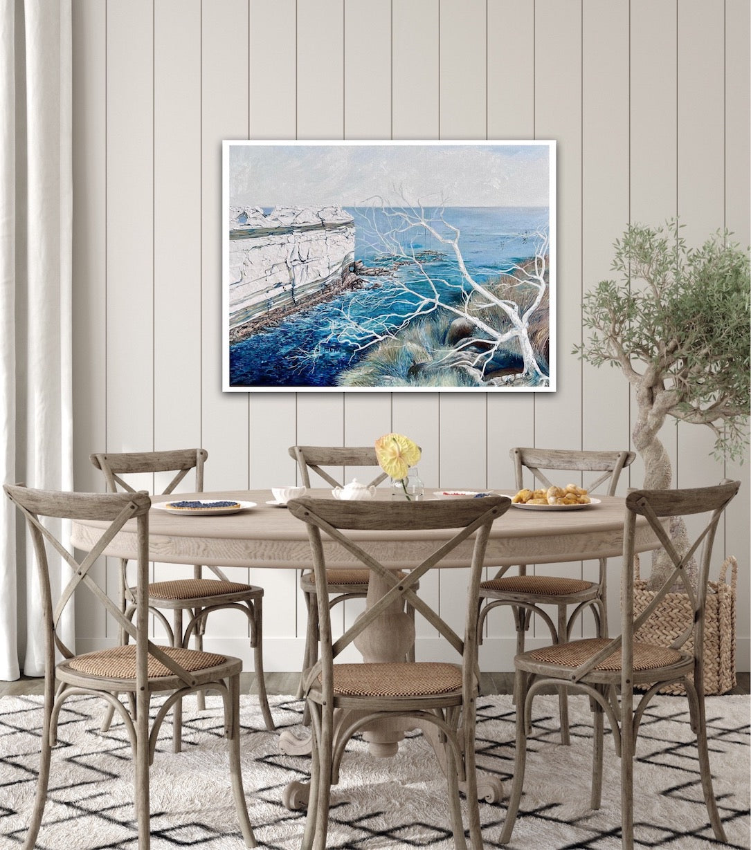 Abstract painting showing a headland jutting out into the ocean, in shades of blue and white. Shown on a panelled wall.