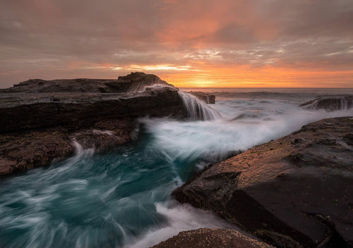 The ocean surges ceaselessly through the 
channel at Werri Point. South Coast, Australia 