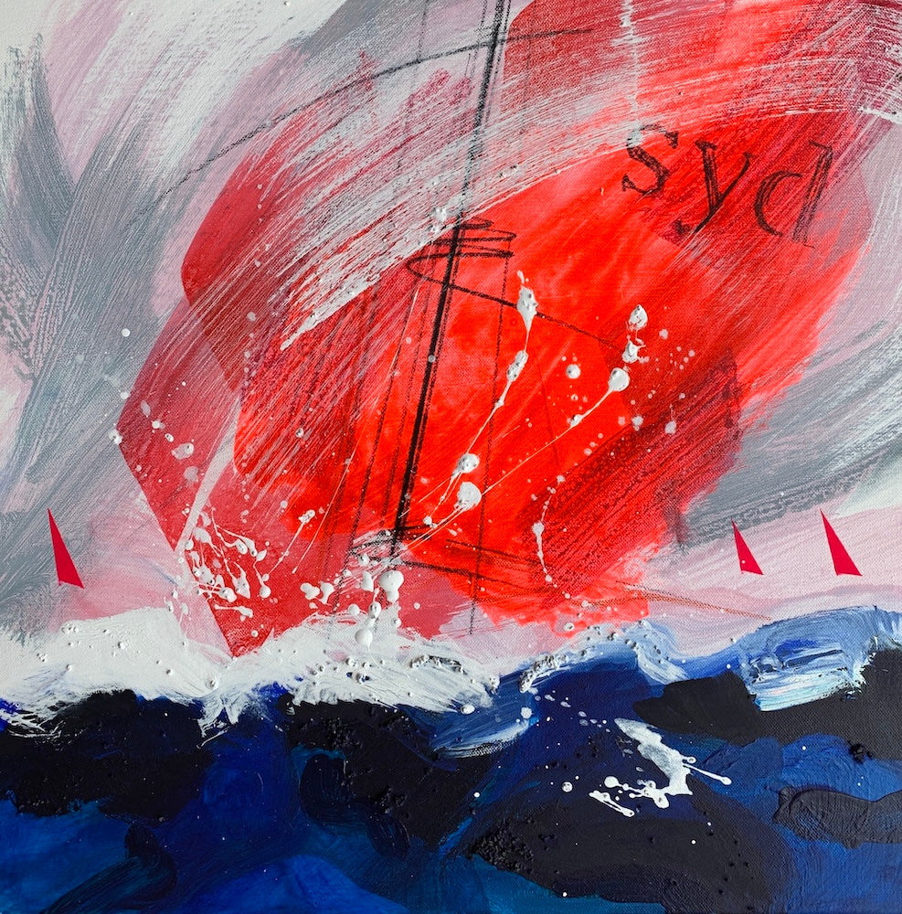 Sailing boat with a red spinnaker in a deep blue ocean with white foam.