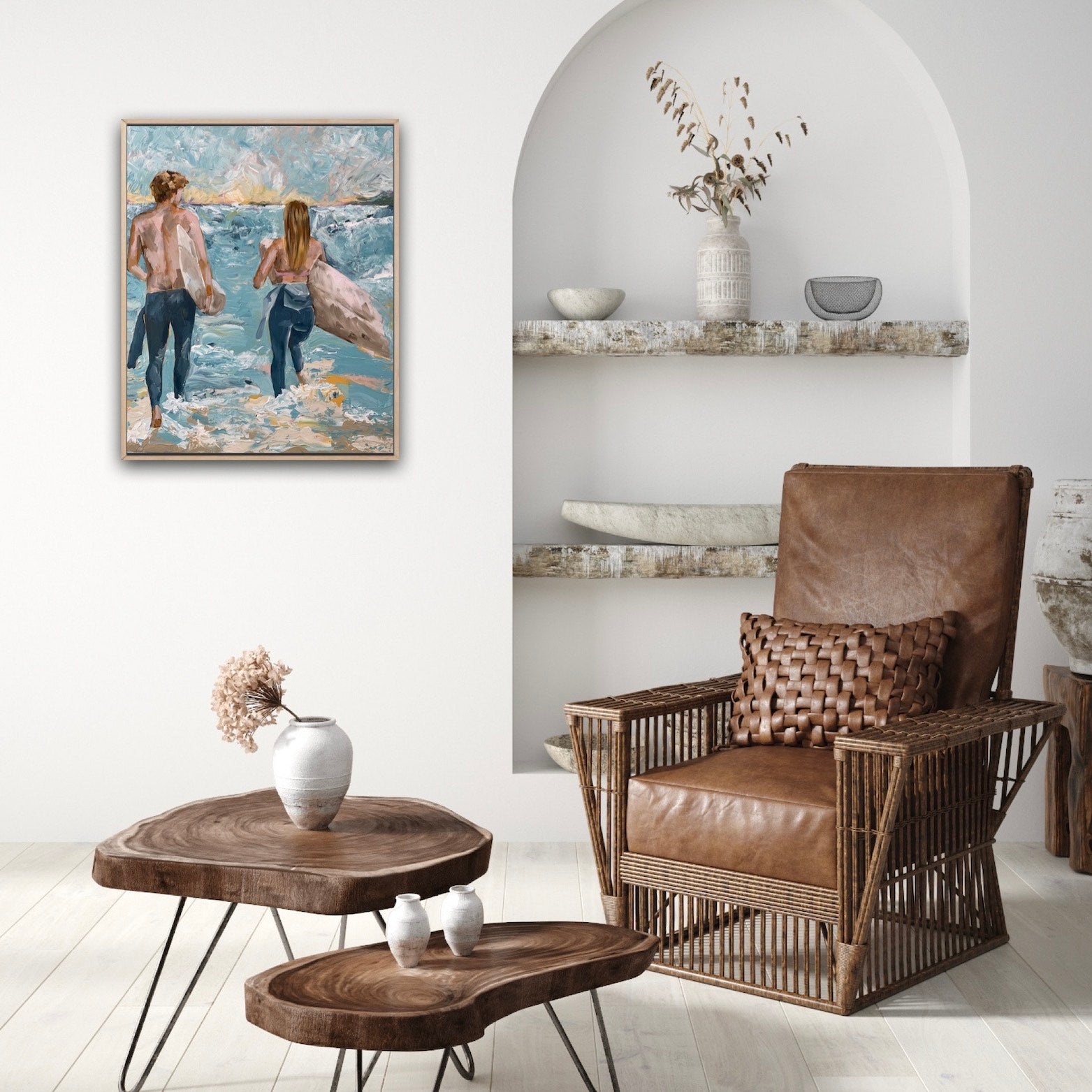 Surf painting with a man and woman standing on the edge of the ocean with surfboards under their arms. Shown on a white sitting room wall.