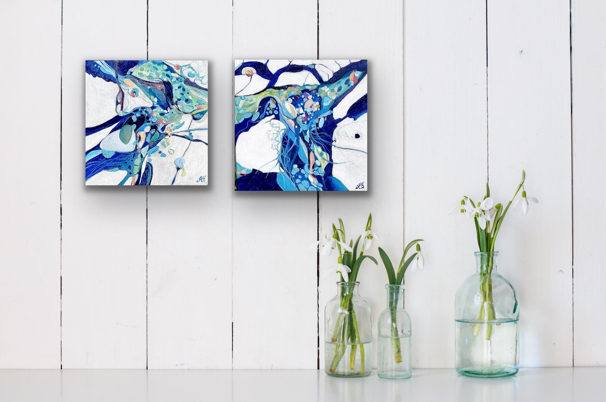 Abstract rock pool in shades of blue, aqua, turquoise, rose, mauve, pink ochre and white. Shown on a panelled wall alongside a matching painting.