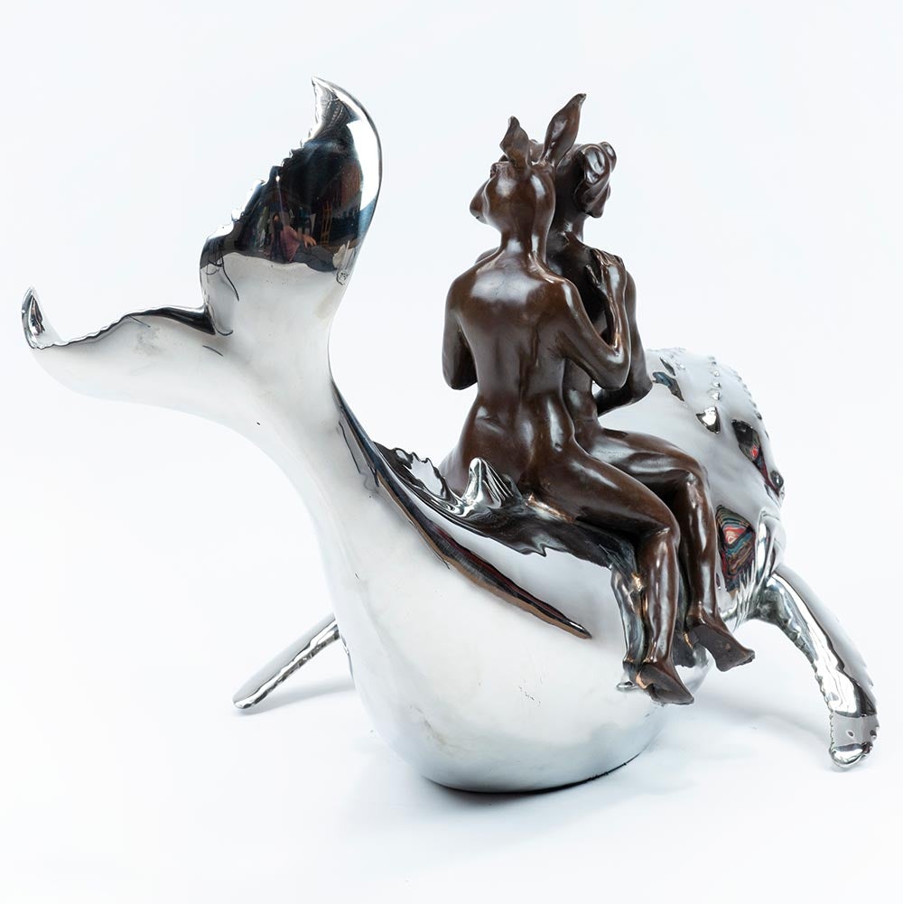 Bronze and stainless steel Sculpture of a dog man and rabbit woman riding on a whale. Rear view.