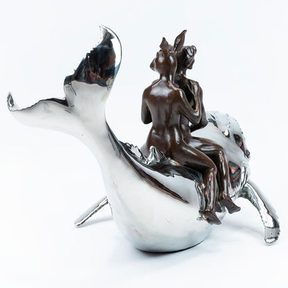 Bronze and stainless steel Sculpture of a dog man and rabbit woman riding on a whale. Rear view.