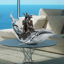 Load image into Gallery viewer, Bronze and stainless steel Sculpture of a dog man and rabbit woman riding on a whale. In situ on a coffee table.
